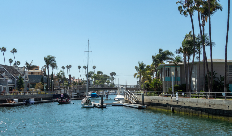 Boats In Canal By Buildings Against Sky