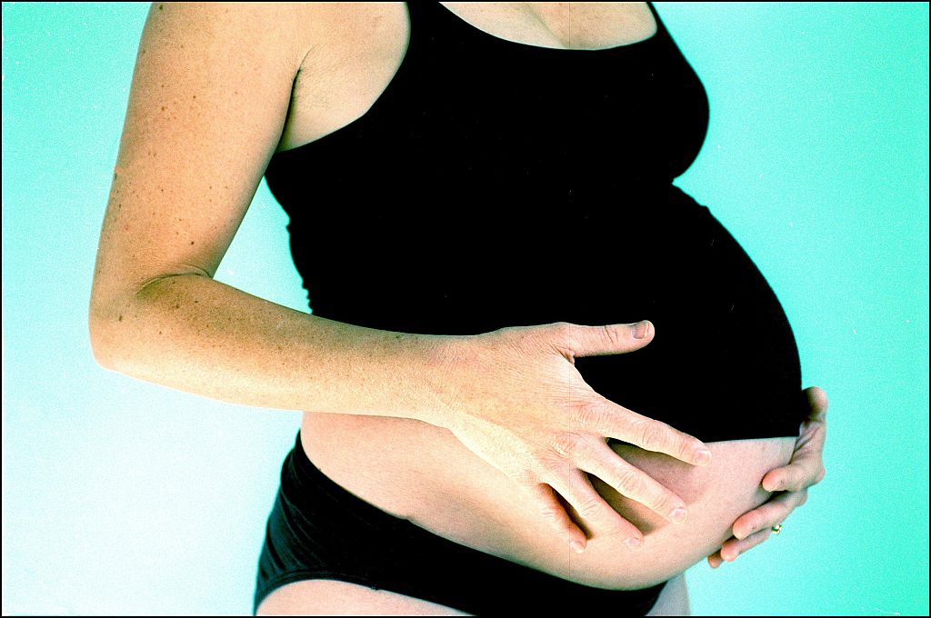 A pregnant woman holds her belly, 12 July 2002. AFR Picture by LOUISE KENNERLEY