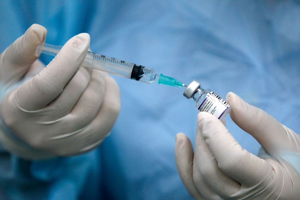 A health worker prepares a dose of Pfizer vaccine before...