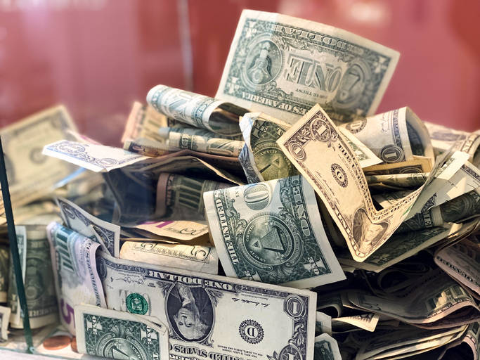 glass donation box with paper currency & coins